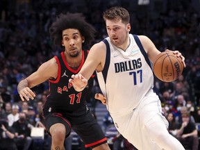 January 19, 2022;  Dallas, TX, USA;  Dallas Mavericks goaltender Luka Doncic (77) heads for the basket as Toronto Raptors forward Justin Champagnie (11) defends during the second quarter at American Airlines Center.