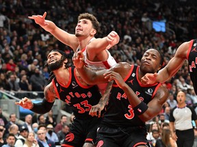 Houston Rockets' Alperen Sengun (centre) battles for position with Raptors' Gary Trent Jr. and O.G. Anunoby in the first half at Scotiabank Arena on Wednesday, Nov. 9, 2022.
