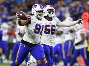 Bills defensive tackle Ed Oliver (left) and defensive end Mike Love (right) celebrate after recovering a fumble from Lions running back Jamaal Williams during second quarter NFL action at Ford Field in Detroit, Thursday, Nov. 24, 2022.