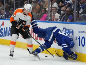 Philadelphia Flyers winger Kieffer Bellows (left) sends Toronto Maple Leafs defenceman TJ Brodie into the boards on Wednesday night at Scotiabank Arena.