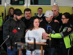 Airdrie paramedic Jayme Erickson is surrounded by family, friends and co-workers while talking with media at a firehall in Airdrie on Tuesday. Erickson's daughter Montana died after a crash near Airdrie on Nov. 15.