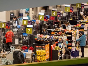 People pay for their items at a grocery store in Toronto November 22, 2022.