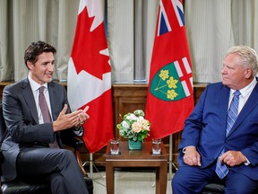 Canada's Prime Minister Justin Trudeau speaks with Ontario Premier Doug Ford at Queen's Park provincial legislature in Toronto, Ontario, on Aug. 30, 2022.