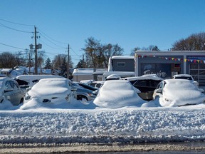 Cars are covered in snow at a dealership in Fort Erie, Ont., Nov. 20, 2022.