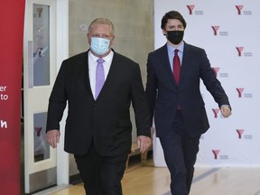 Canadian Prime Minister Justin Trudeau, right, and Ontario Premier Doug Ford walk together after reaching and agreement in $10-a-day child-care program deal in Brampton on Monday, March 28, 2022.