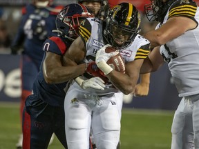 Montreal Alouettes' Micah Awe wraps-up Hamilton Tiger-Cats' Wes Hills during second half CFL football action in Montreal on Friday, Sept. 23, 2022.