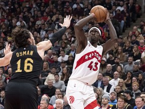 Raptors’ Pascal Siakam (right) scores on Cleveland Cavaliers’ Cedi Osman during the first half in Toronto on Monday, Nov. 28, 2022.