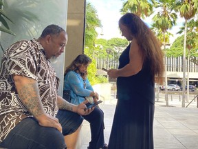 Chico Kaonohi, left, prays with Priscilla Hoopii, centre, and Lana Vierra, right, outside U.S. District Court in Honolulu, Thursday, Nov. 17, 2022, after his Native Hawaiian son was found guilty of a hate crime in the 2014 beating of a white man.