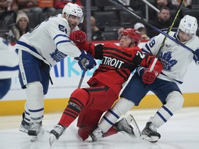 Maple Leafs' Mark Giordano (55) and Calle Jarnkrok (19) knock Red Wings' Lucas Raymond off the puck during the second period on Monday, Nov. 28, 2022, in Detroit.