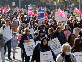 CUPE Ontario members and supporters wave demonstrate outside of the Queen's Park Legislative Building in Toronto, Friday, Nov. 4, 2022. THE CANADIAN PRESS/Cole Burston