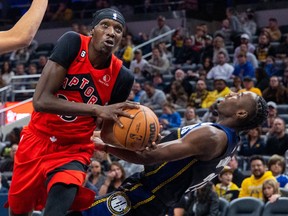 Raptors forward Chris Boucher (left) goes hard to the hoop against Pacers’ Aaron Nesmith in Indianapolis last night.