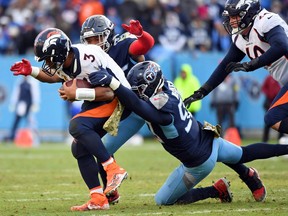 Nov 13, 2022; Nashville, Tennessee, USA; Denver Broncos quarterback Russell Wilson (3) is tackled by Tennessee Titans defensive end DeMarcus Walker (95) and linebacker Rashad Weaver (99) during the second half at Nissan Stadium. Mandatory Credit: Christopher Hanewinckel-USA TODAY Sports