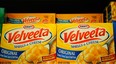 Boxes Velveeta Shells and Cheese sit on a store shelf.