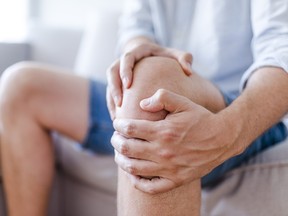 Close-up of man's knee, suffering from pain.