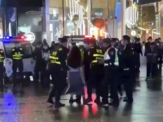 A person is detained by police officers during a demonstration against COVID-19 restrictions in Hangzhou, China in this still image taken from a video released November 28, 2022.
