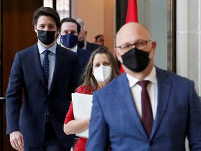 Canada's Prime Minister Justin Trudeau arrives with Canada's Minister of Justice and Attorney General of Canada David Lametti, Canada's Deputy Prime Minister and Minister of Finance Chrystia Freeland, and Canada's Minister of Public Safety Marco Mendicino at a news conference in Ottawa, Ontario, Canada, on Feb. 23, 2022.