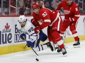 Toronto Maple Leafs left wing Nicholas Robertson and Detroit Red Wings defenseman Moritz Seider battle for the puck in the third period at Little Caesars Arena.