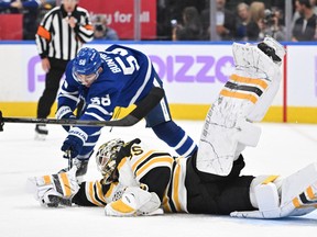 Boston Bruins goalie Linus Ullmark dives to reach a loose puck ahead of Maple Leafs' Michael Bunting in the second period at Scotiabank Arena on Saturday, Nov. 5, 2022.