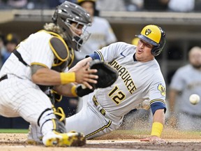 Brewers baserunner Hunter Renfroe, right, scores ahead of the throw to Jorge Alfaro of the Padres during MLB action at Petco Park in San Diego, May 23, 2022.