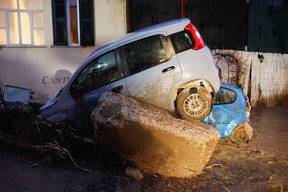Damaged cars and debris pile up at a street following a landslide on the Italian holiday island of Ischia, Italy, Nov. 26, 2022.