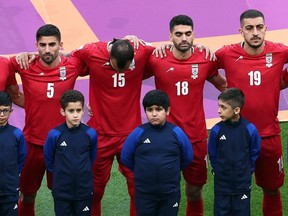 Iran's players line up during the national anthems before their match against England, during the FIFA World Cup at Khalifa International Stadium in Doha, Qatar, Monday, Nov. 21, 2022.