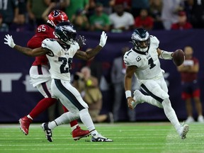Eagles quarterback Jalen Hurts, right, runs the ball against the Texans during NFL action at NRG Stadium in Houston, Thursday, Nov. 3, 2022.