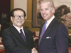 This file photo taken on Aug. 8, 2001 shows Chinese President Jiang Zemin shaking hands with Joe Biden, then-senator with the U.S. Senate Foreign Relations Committee, at the resort of Beidaihe, east of Beijing.