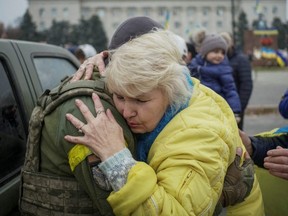 A local resident hugs a Ukrainian serviceman as people celebrate following Russia's retreat from Kherson, in central Kherson, Ukraine, Saturday, Nov. 12, 2022.