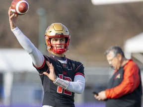 Arnaud Desjardins, starting quarterback for the Laval Rouge et Or, keeps his arm warm Thursday as head coach Glen Constantin looks on in the background. Laval and the Saskatchewan Huskies meet in London at Alumni Field Saturday for the Vanier Cup. (Mike Hensen/The London Free Press)