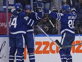 Toronto Maple Leafs defenceman Jordie Benn (18) celebrates his goal against the Vancouver Canucks with forward Auston Matthews (34) and forward William Nylander (88) during the second period at Scotiabank Arena.