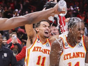 Atlanta, Georgia, USA; Atlanta Hawks guard Trae Young (11) dumps water on forward AJ Griffin (14) after an overtime victory against the Toronto Raptors.