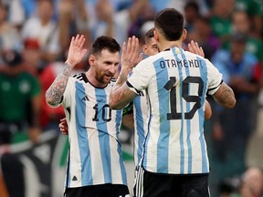 Argentina's Lionel Messi and Nicolas Otamendi celebrate after their match against Mexico at  Lusail Stadium in Lusail, Qatar, Nov. 26, 2022.