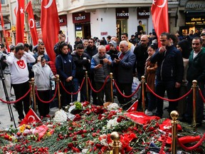 People lay flowers to pay tribute to the victims of a blast that took place on Istiklal Avenue, a popular spot for shoppers and tourists, in Istanbul, Turkey, November 15, 2022.
