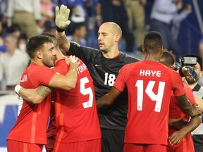 Canada's forward Lucas Cavallini (L) celebrates scoring with teammates during a friendly football match between Canada and Japan at Al-Maktoum Stadium in Dubai, UAE on November 17, 2022.