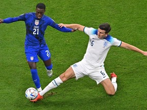 USA's forward #21 Timothy Weah (L) fights for the ball with England's defender #06 Harry Maguire during the Qatar 2022 World Cup Group B football match between England and USA at the Al-Bayt Stadium in Al Khor, north of Doha on Friday.