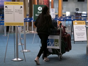 Signage for a COVID-19 screening centre is pictured at Vancouver International Airport in Richmond, B.C., Feb. 19, 2021.