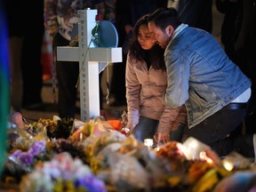 People embrace during a candlelight vigil on a corner near the site of a weekend mass shooting at a gay bar, late Monday, Nov. 21, 2022, in Colorado Springs, Colo.