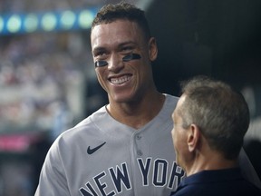New York Yankees right fielder Aaron Judge smiles in the dugout after hitting home run number sixty-two to break the American League home run record in the first inning against the Texas Rangers at Globe Life Field.