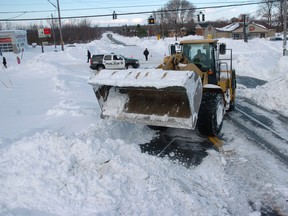 A high loader works to clear snow along McKinley Park Avenue on November 20, 2014 in the suburb of Blasdell, New York.