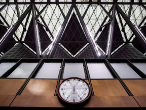 The structure holding up the glass roof is reflected in a clock on the wall of the interim House of Commons Chamber West Block on Parliament Hill in Ottawa on June 15, 2018.