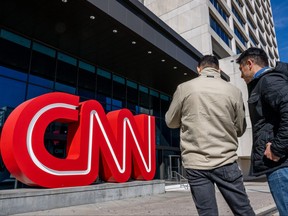 People stand outside of the world headquarters for the CNN on Nov. 17, 2022 in Atlanta, Ga.