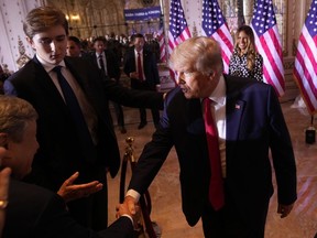 Former U.S. president Donald Trump greets people after announcing he is running for president for the third time as he speaks at Mar-a-Lago in Palm Beach, Nov. 15, 2022. Son Barron Trump watches.