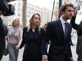 Former Theranos CEO Elizabeth Holmes (centre) arrives at federal court with her partner Billy Evans (right) and mother Noel Holmes on Nov. 18, 2022 in San Jose, Calif.