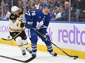 Toronto Maple Leafs defenseman TJ Brodie (78) plays the puck as Boston Bruins forward David Pastrnak (88) pursuits him in the first period at Scotiabank Arena.