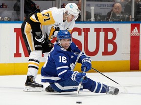 Evgeni Malkin of the Pittsburgh Penguins trips up Mitch Marner of the Toronto Maple Leafs at the Scotiabank Arena on November 11, 2022 in Toronto.