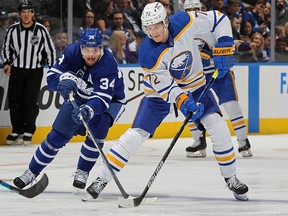 Tage Thompson of the Buffalo Sabres skates with the puck against Auston Matthews of the Toronto Maple Leafs at Scotiabank Arena on April 12, 2022 in Toronto.
