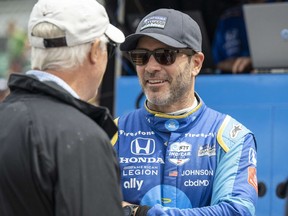 May 27, 2022; Indianapolis, Indiana, USA; Chip Ganassi Racing driver Jimmie Johnson (48) talks with someone in his pit before carb day practice for the 106th Indianapolis 500 at the Indianapolis Motor Speedway.