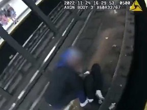 This image taken from a screengrab of a New York City police's body camera footage shared on NYPD's Twitter account shows a bystander helping a person who fell on the subway tracks right before two officers went onto the tracks to assist them.