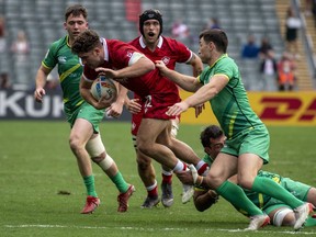 Canada's David Richard is tackled by players from Ireland during the second day of the Hong Kong Sevens rugby tournament in Hong Kong, Saturday, Nov. 5, 2022.