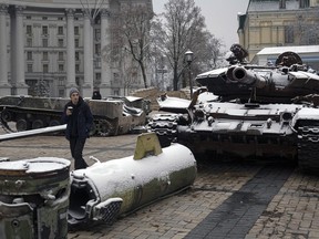 People walk past a display of destroyed Russian tanks and armoured vehicles after snowfall in downtown Kyiv, Ukraine, Thursday, Nov. 17, 2022.